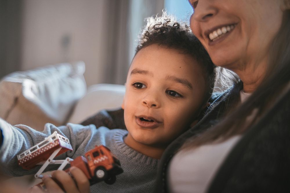 Young African American boy reading with woman