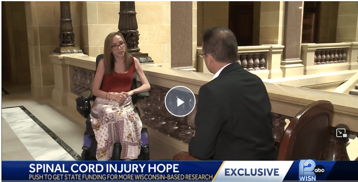 white woman in a wheelchair speaking with a white man news anchor