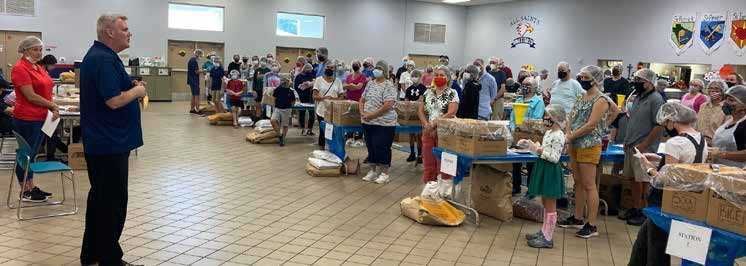 Volunteers pack meals as a family
