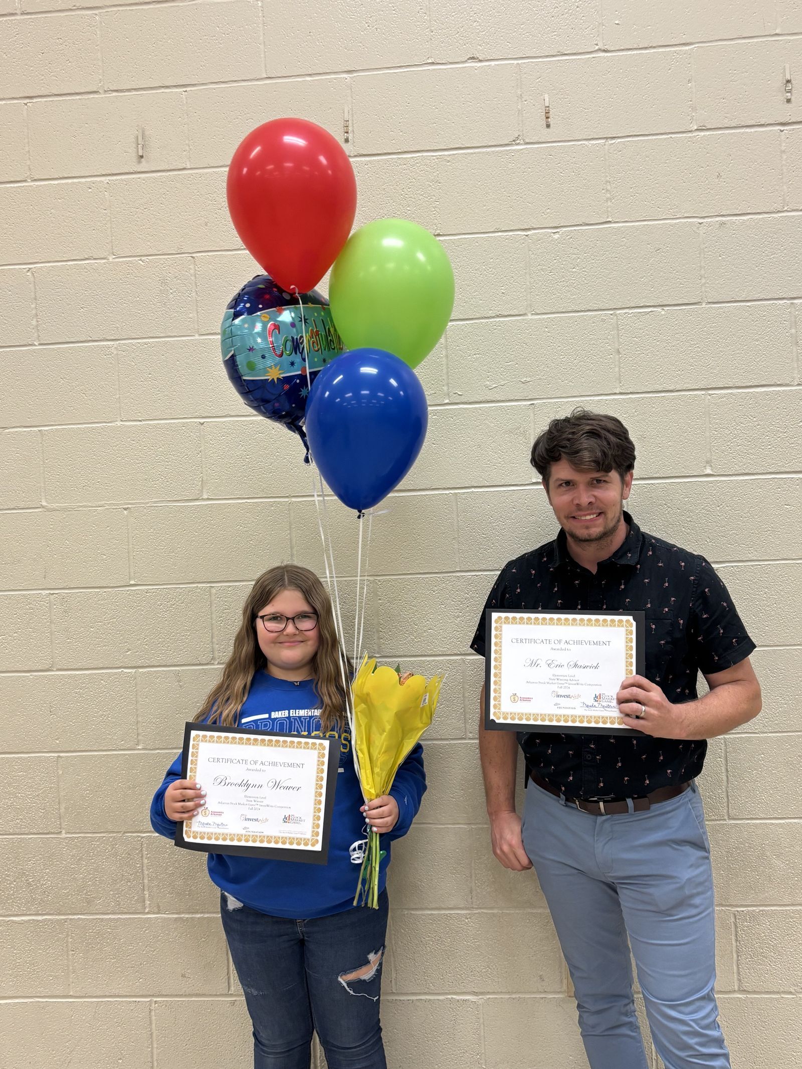 two young girls holding certificates and wearing medallions