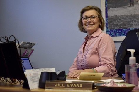 Executive Director Jill Evans sits at her desk