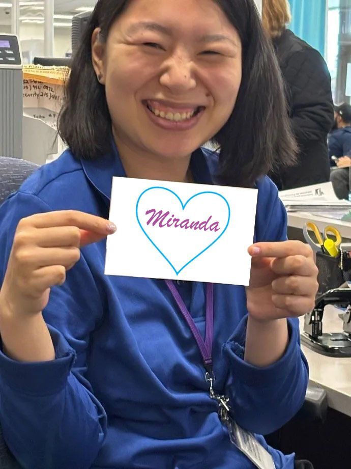 Miranda smiling in a blue PennDOT uniform holding a piece of paper that has star on it saying Samera.
