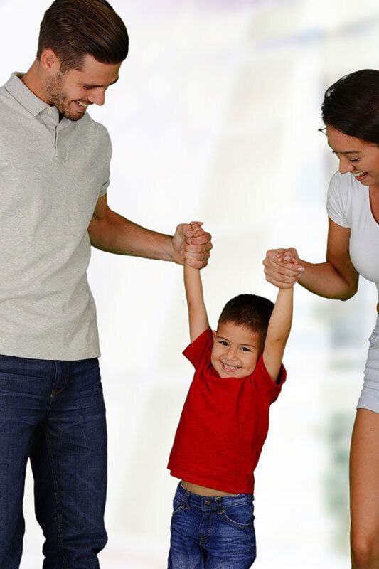 Parents holding their child's hands.