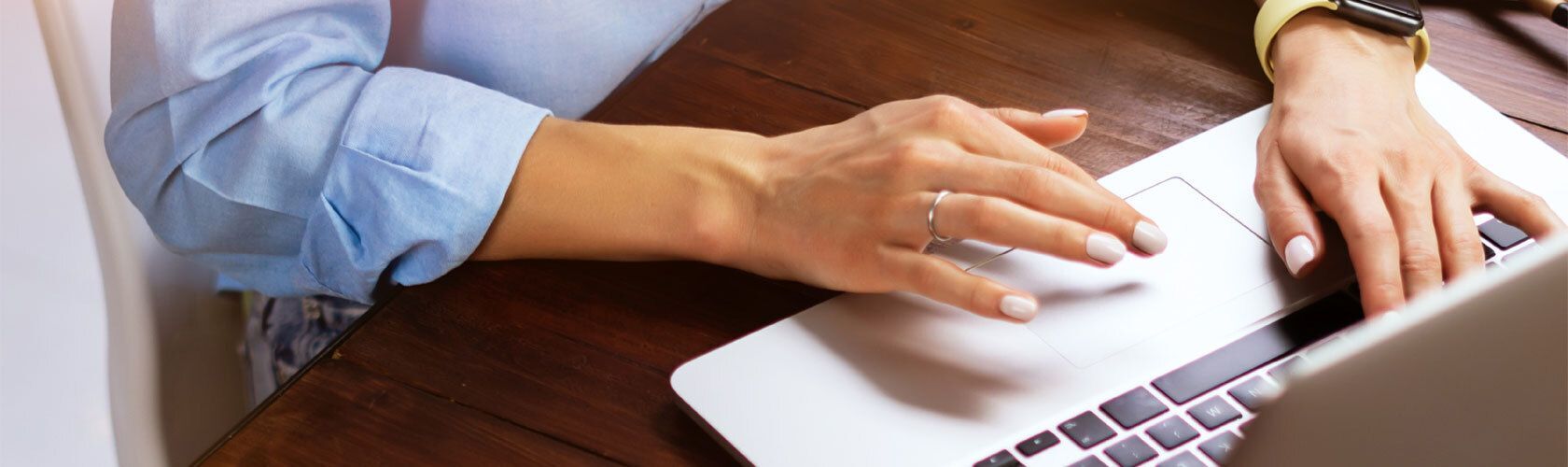 Photo of a woman's hand at a laptop