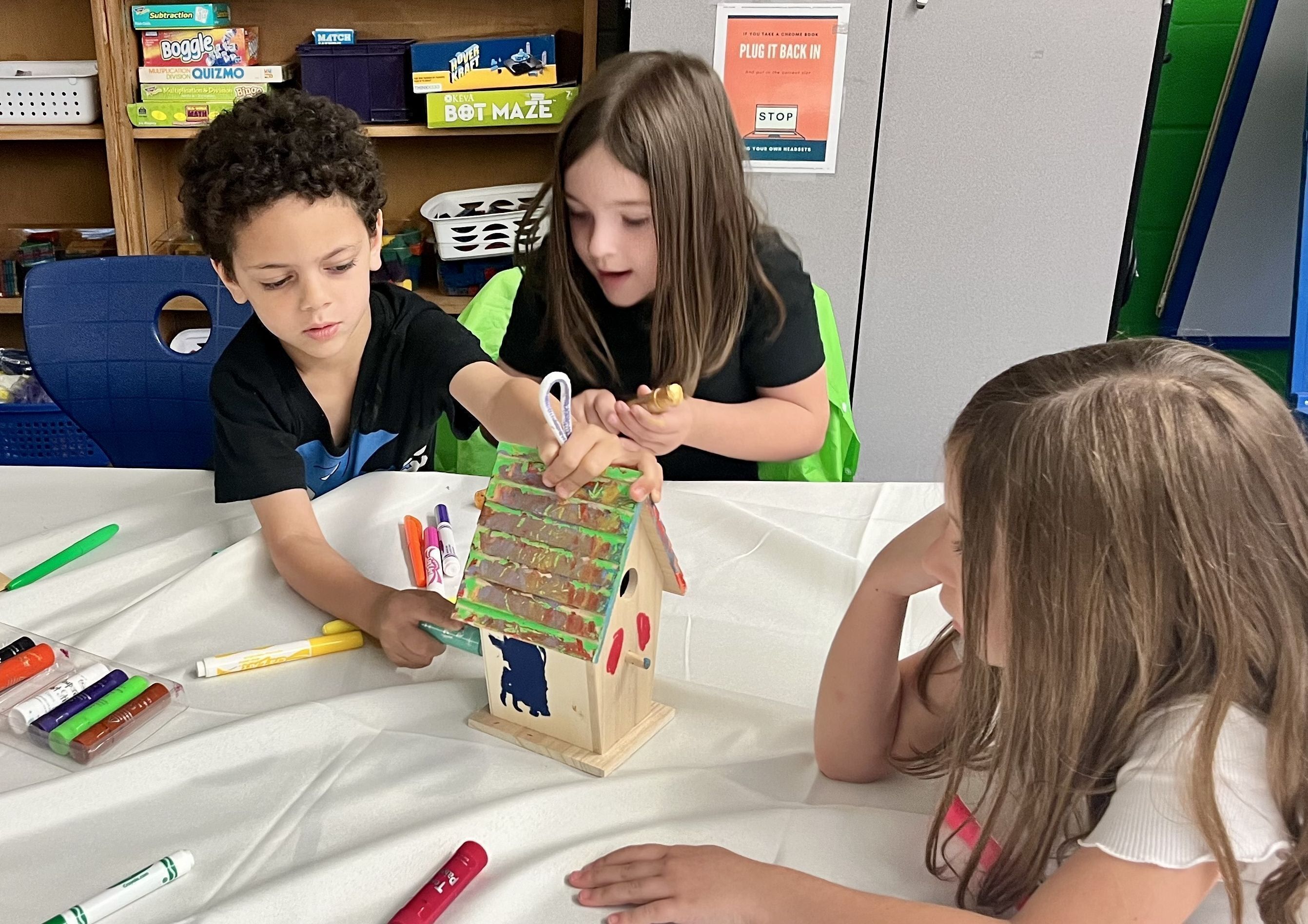 Facilitator helping a student color a butterfly drawing