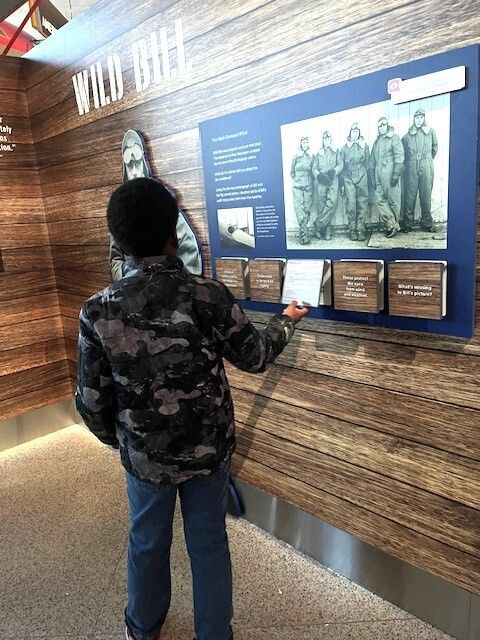 student reading information on wall presentation