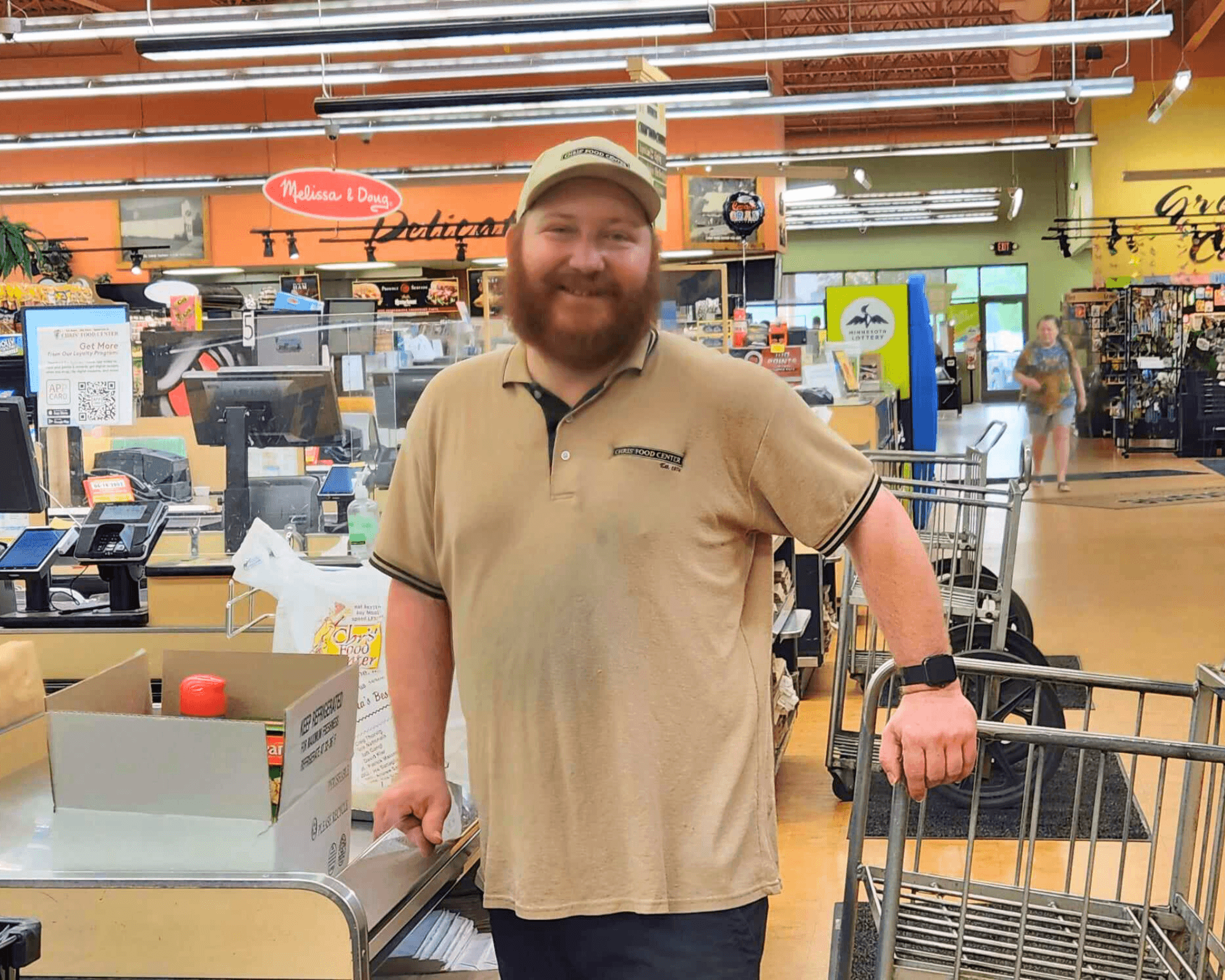 man smiling at camera leaning on shopping cart