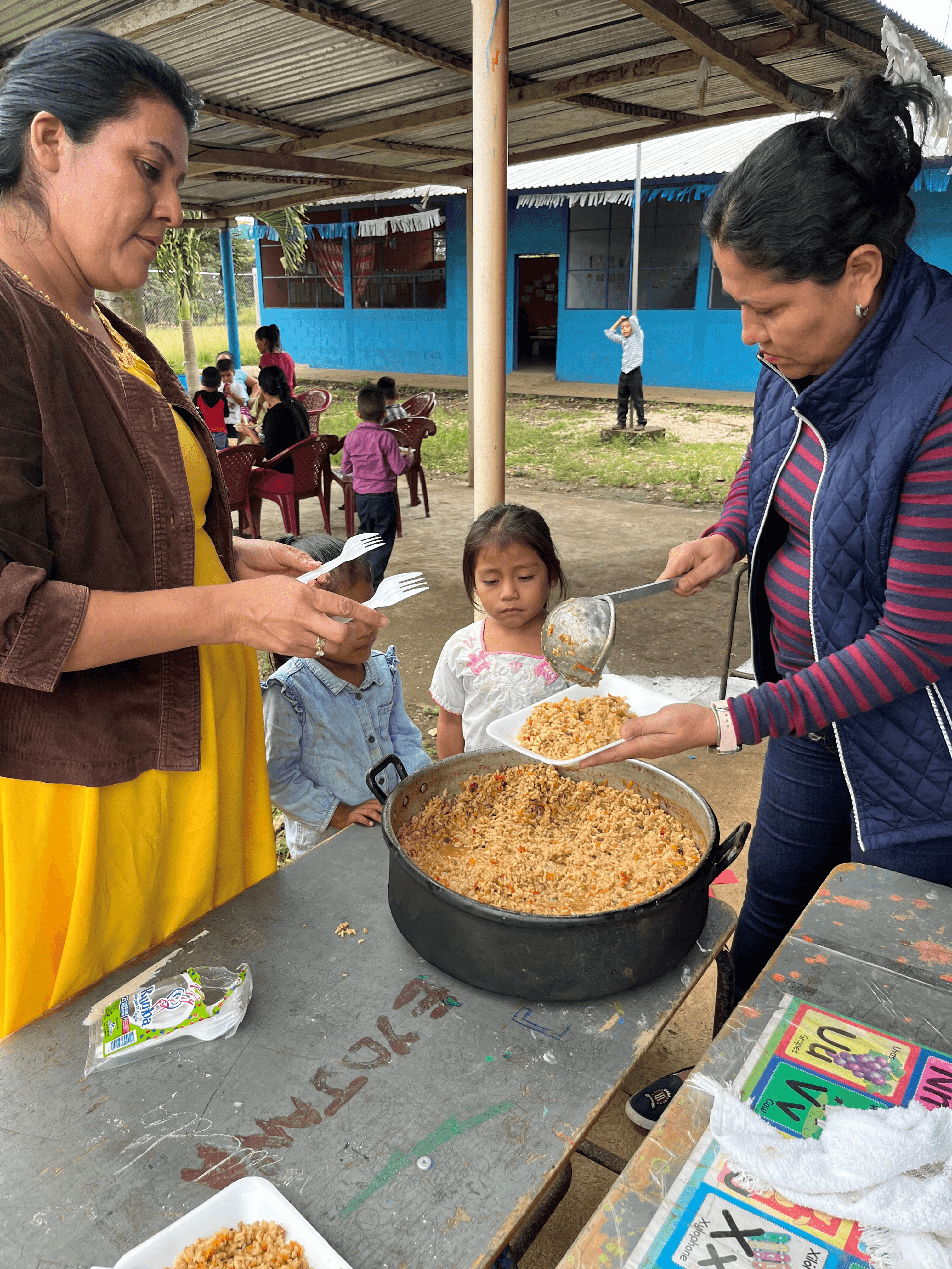 child getting a cooked kcah meal in Guatemala