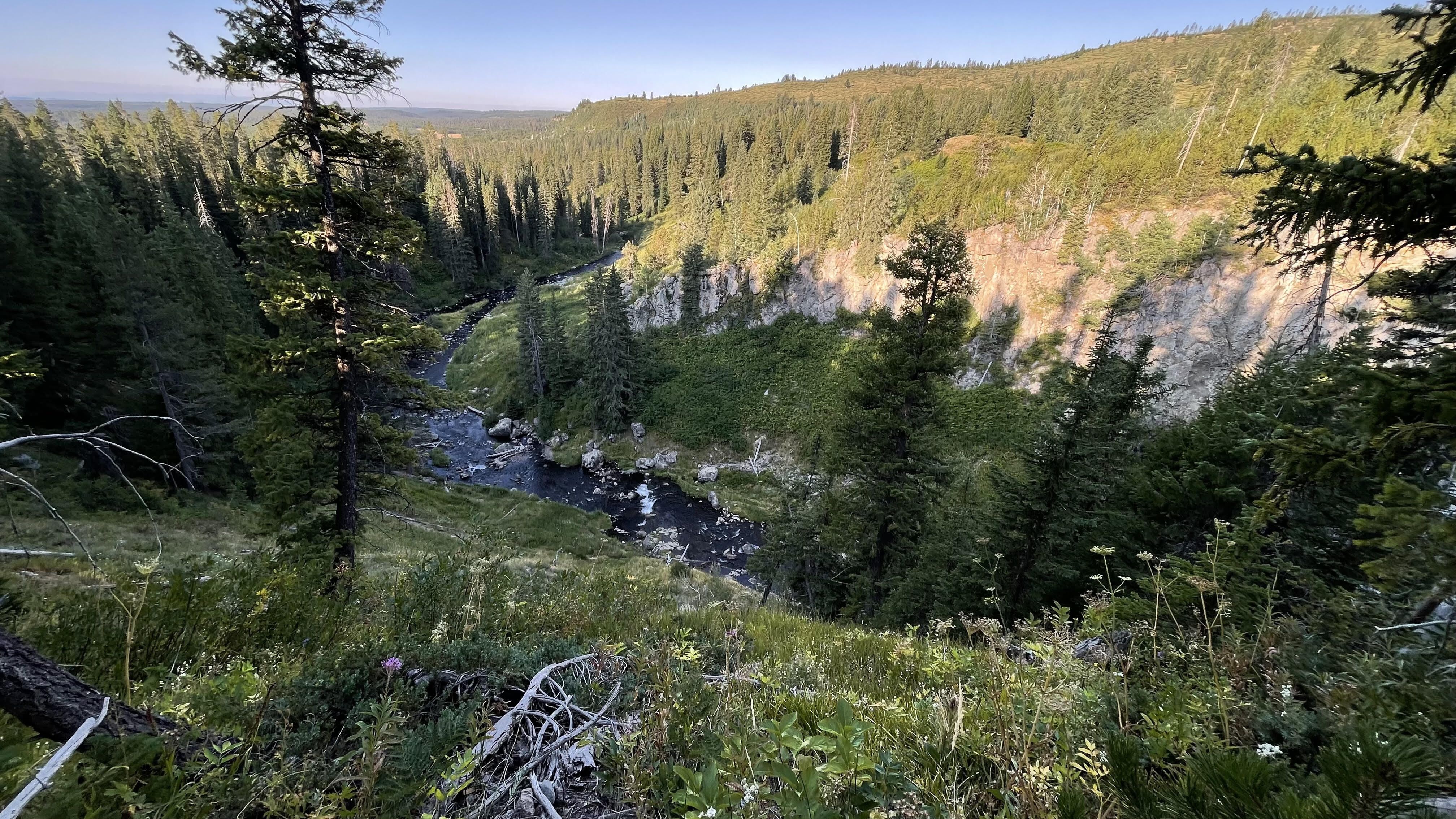 A view down into a valley with a stream at the bottom.