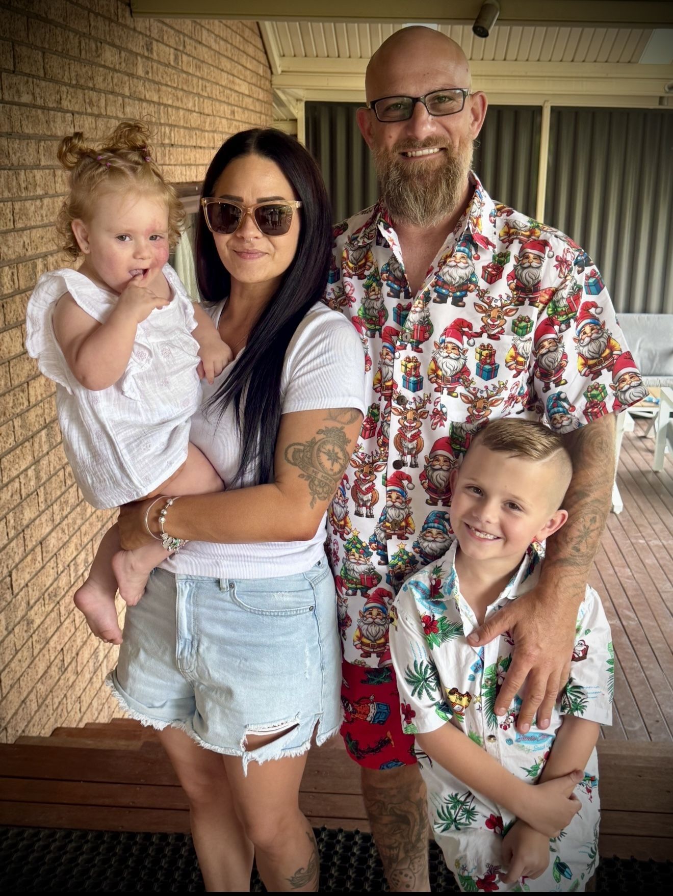 Photo of family, mom and dad, with kids smiling at the camera