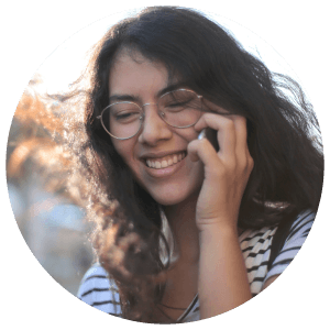 Photo of a young woman smiling while talking on her phone.