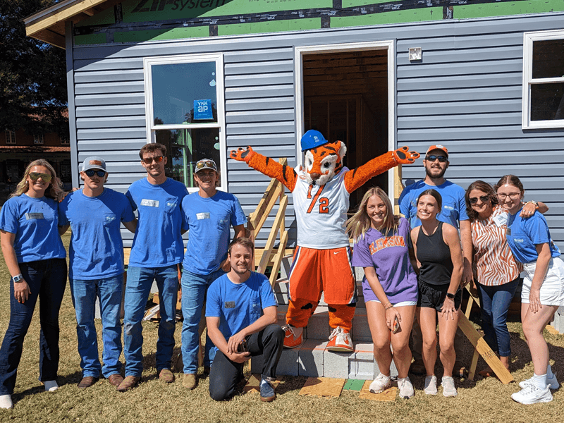 Students from the Pickens County Habitat for Humanity at Clemson University Chapter pose alongside the Clemson Tiger in front of the completed 2023 Homecoming Build house.