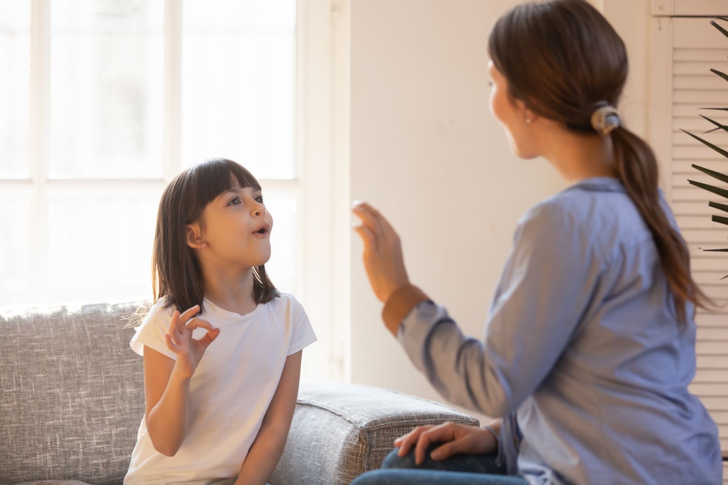 Counselor doing sign language with a young girl.