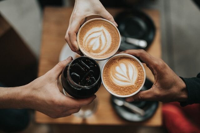 Diverse people clinking their coffee cups together