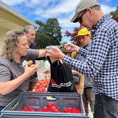 Photo of volunteers giving food to recipients of the Earle Baum Center