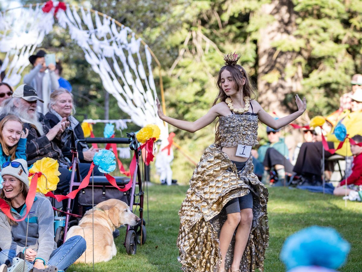 A photo of a girl posing for the camera on the runway dressed in gold.