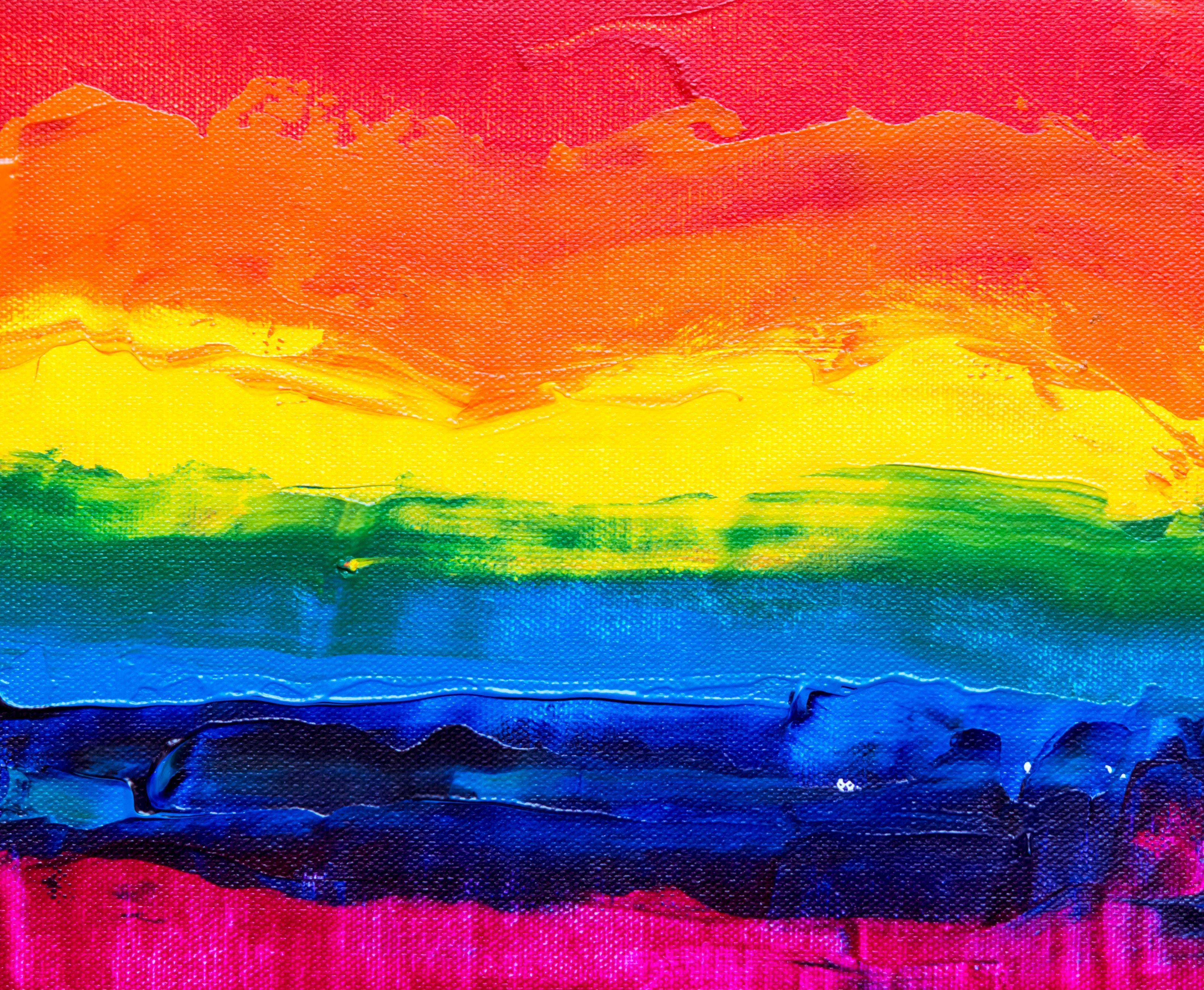 A closeup of a painting with horizontal, free-form stripes the colors of a rainbow.