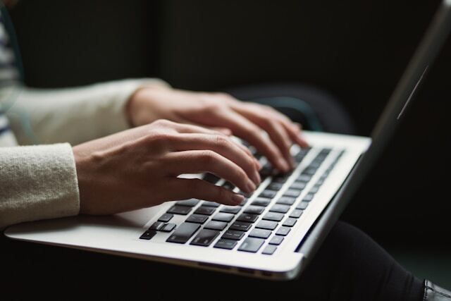 hands typing on laptop