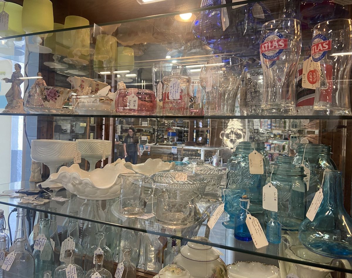 Vintage and collectible glassware and decorative pieces displayed in a glass cabinet at Habitat ReStore Zephyrhills