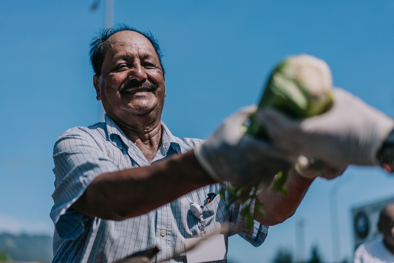 Volunteer handing celery to a recipient
