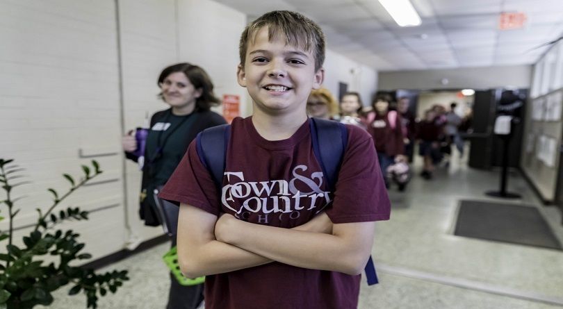 Student smiling in a hallway