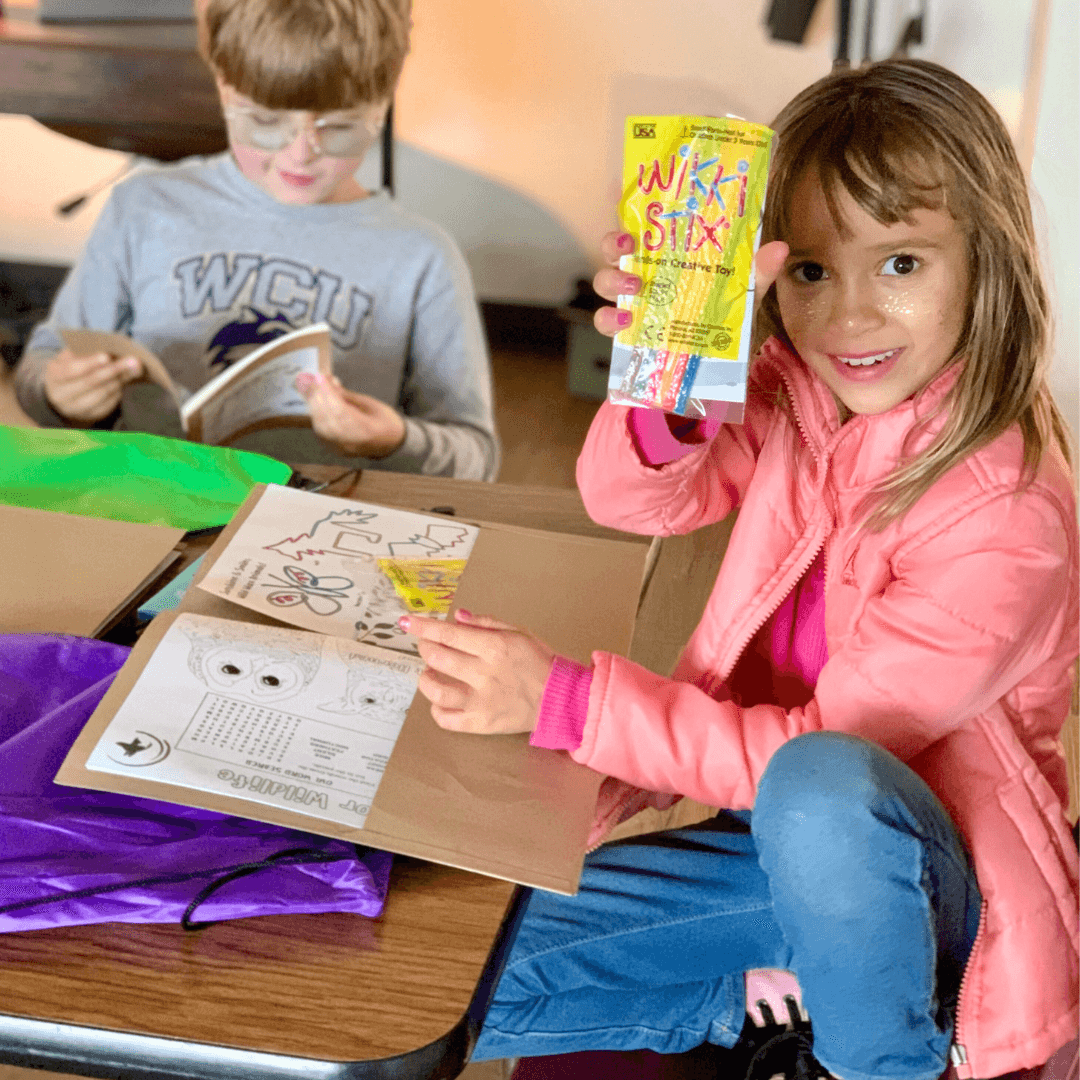 Excited student shows off contents of a Sunshine & Smiles kit