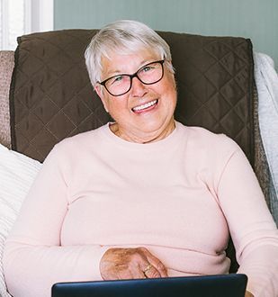 Older woman online smiling in her home