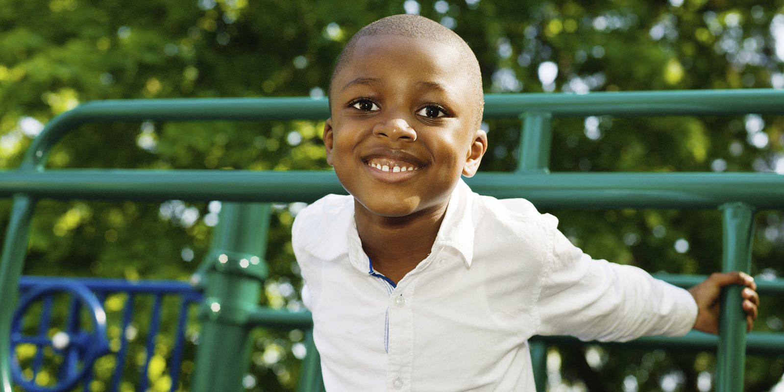 Young boy at playground smiling - CASA for Children