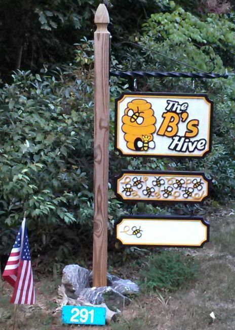 M4760  - Round  Wood 4" Diameter Post with Heavy Duty  Wrought iron Scroll Bracket Supporting  Three Hanging HDU Signs for the " B's Hive" Store.