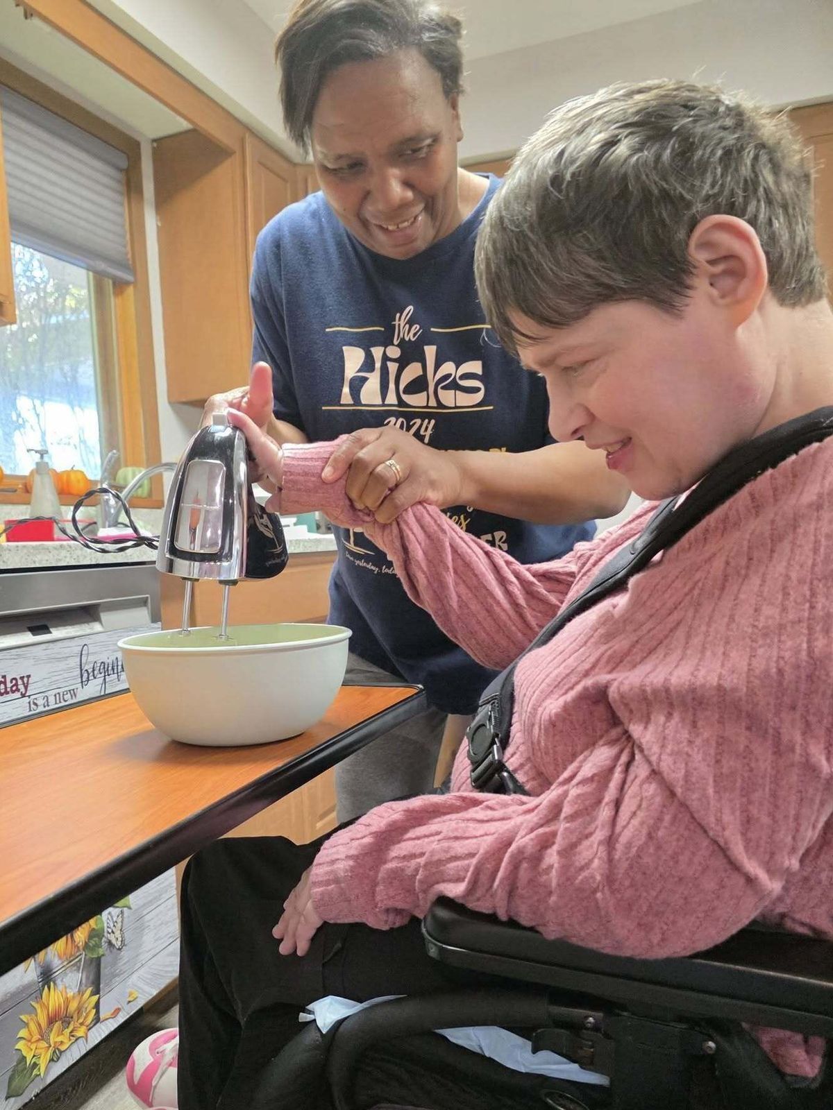 A young girl is laying on a bed and laughing while a dog rests on her chest.