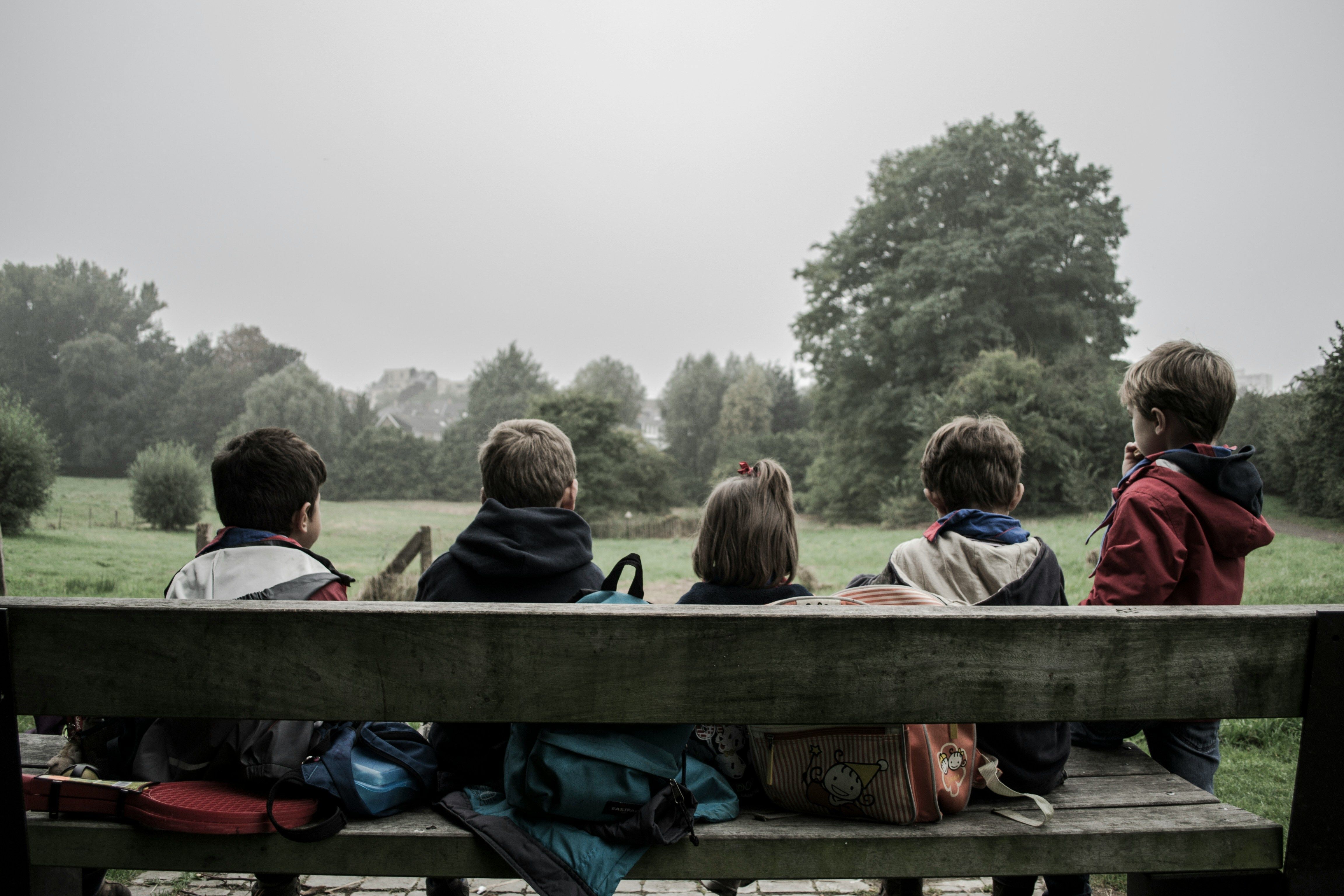 five smiling children of diverse races and genders lying in the grass under the Georgia Center for Child Advocacy logo