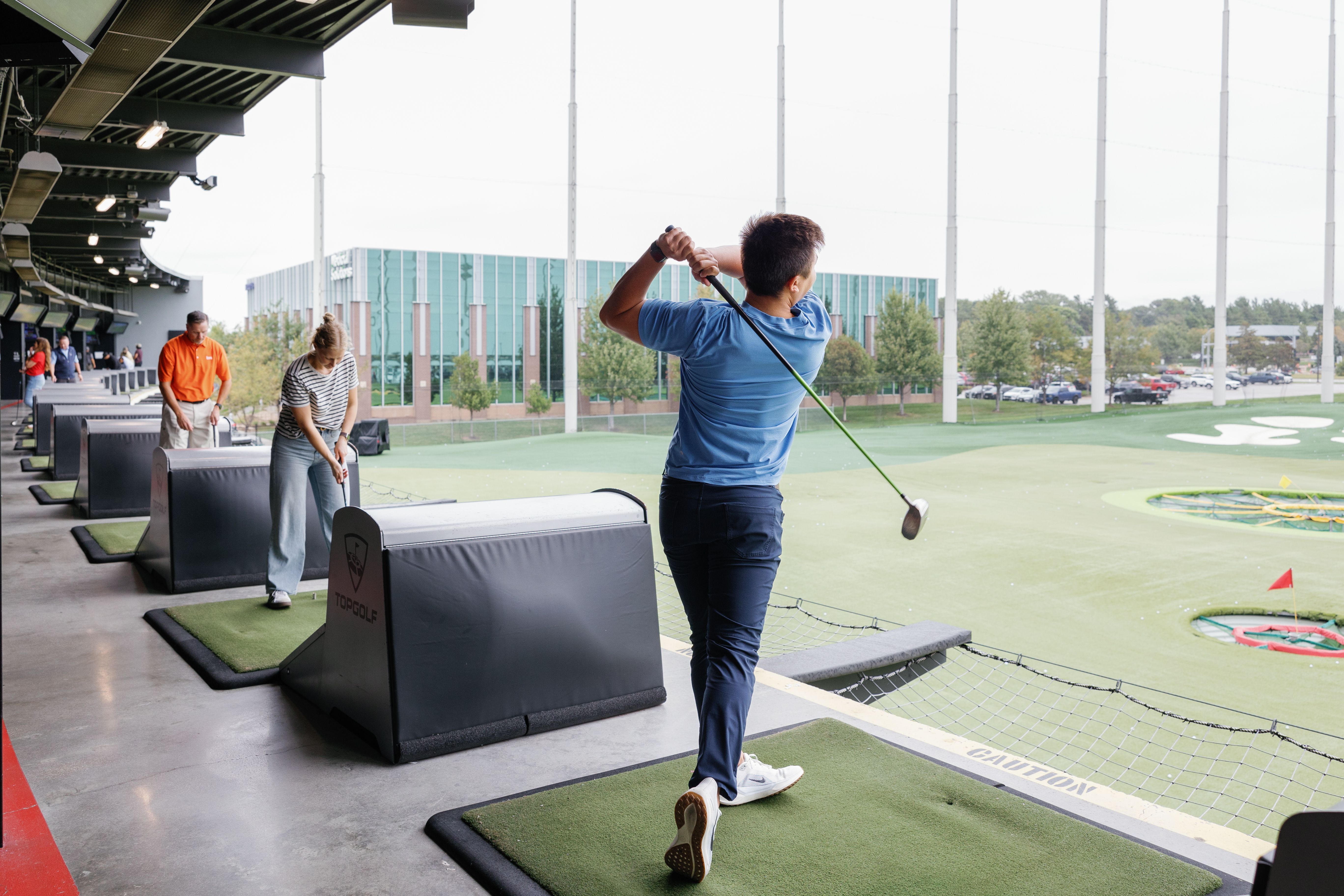 Group of participants at Topgolf sitting and playing golf