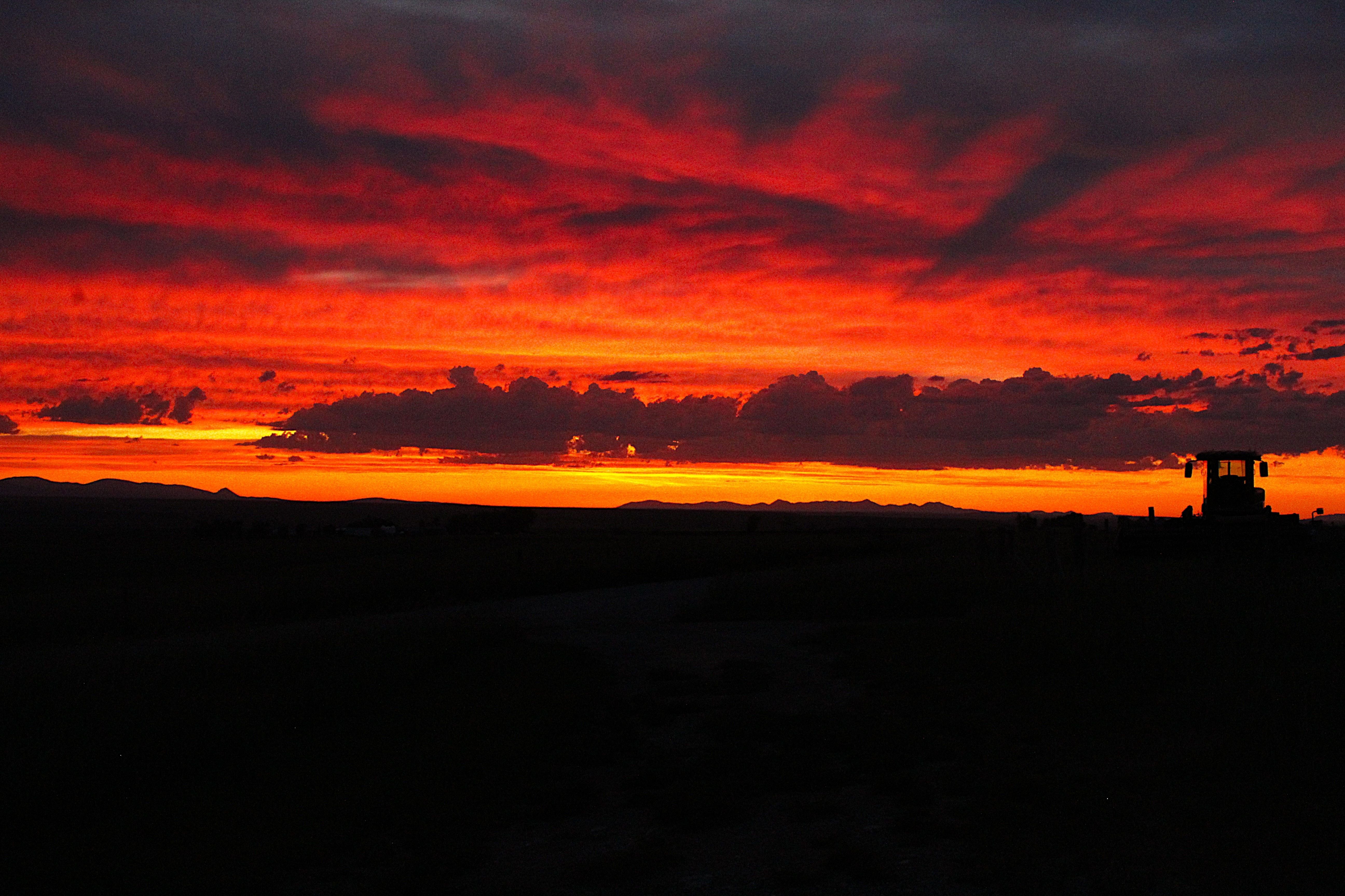 A bright red and orange sunset on the prairie