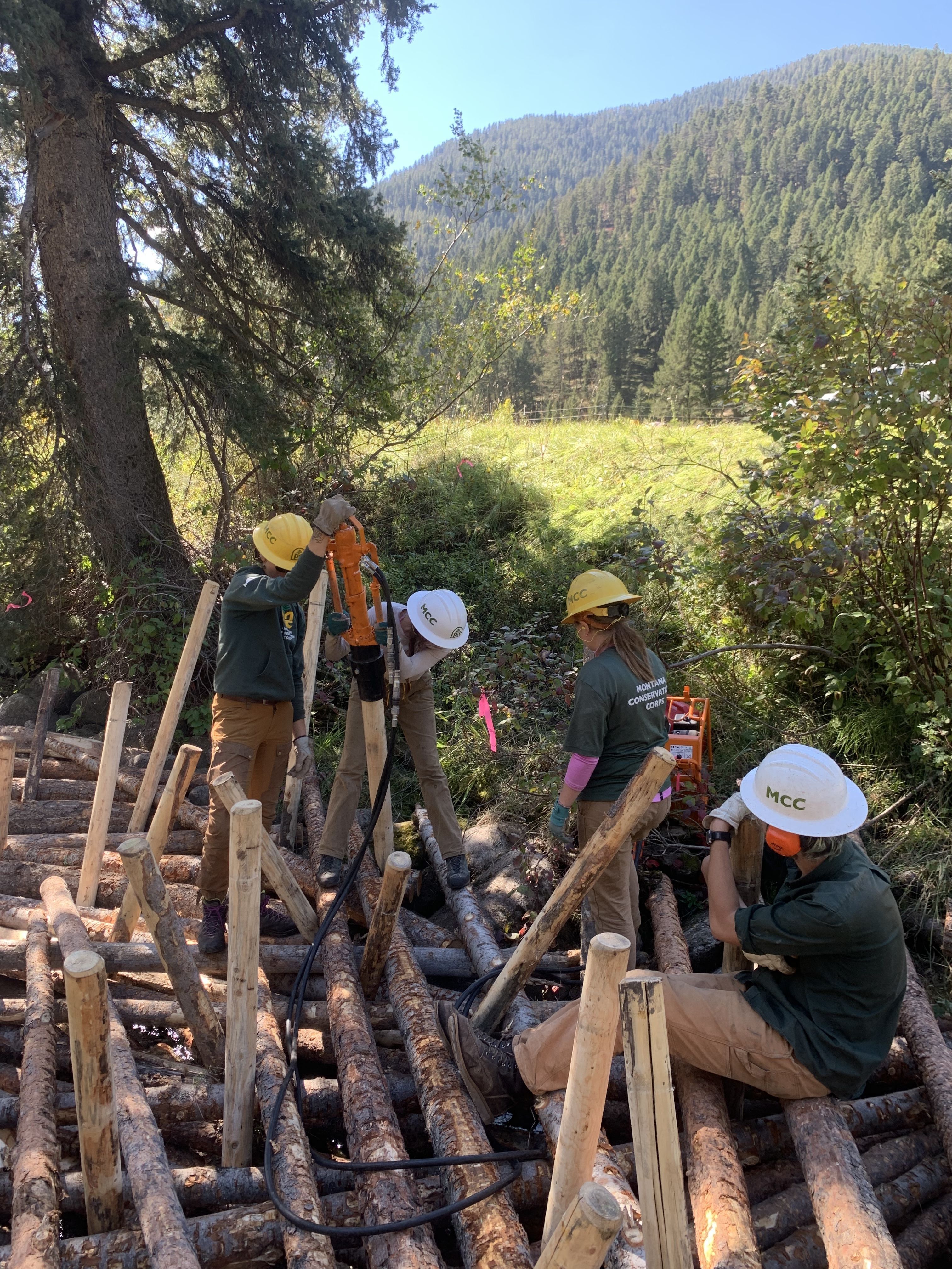 Crew members are placing logs into a large logjam.