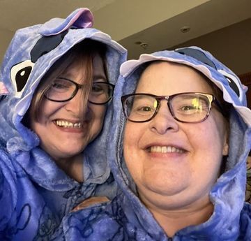 Beth and Amy wear matching hooded pajamas and smile at the camera