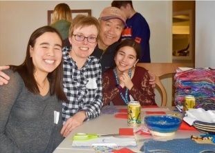 Family smiling while doing crafts.