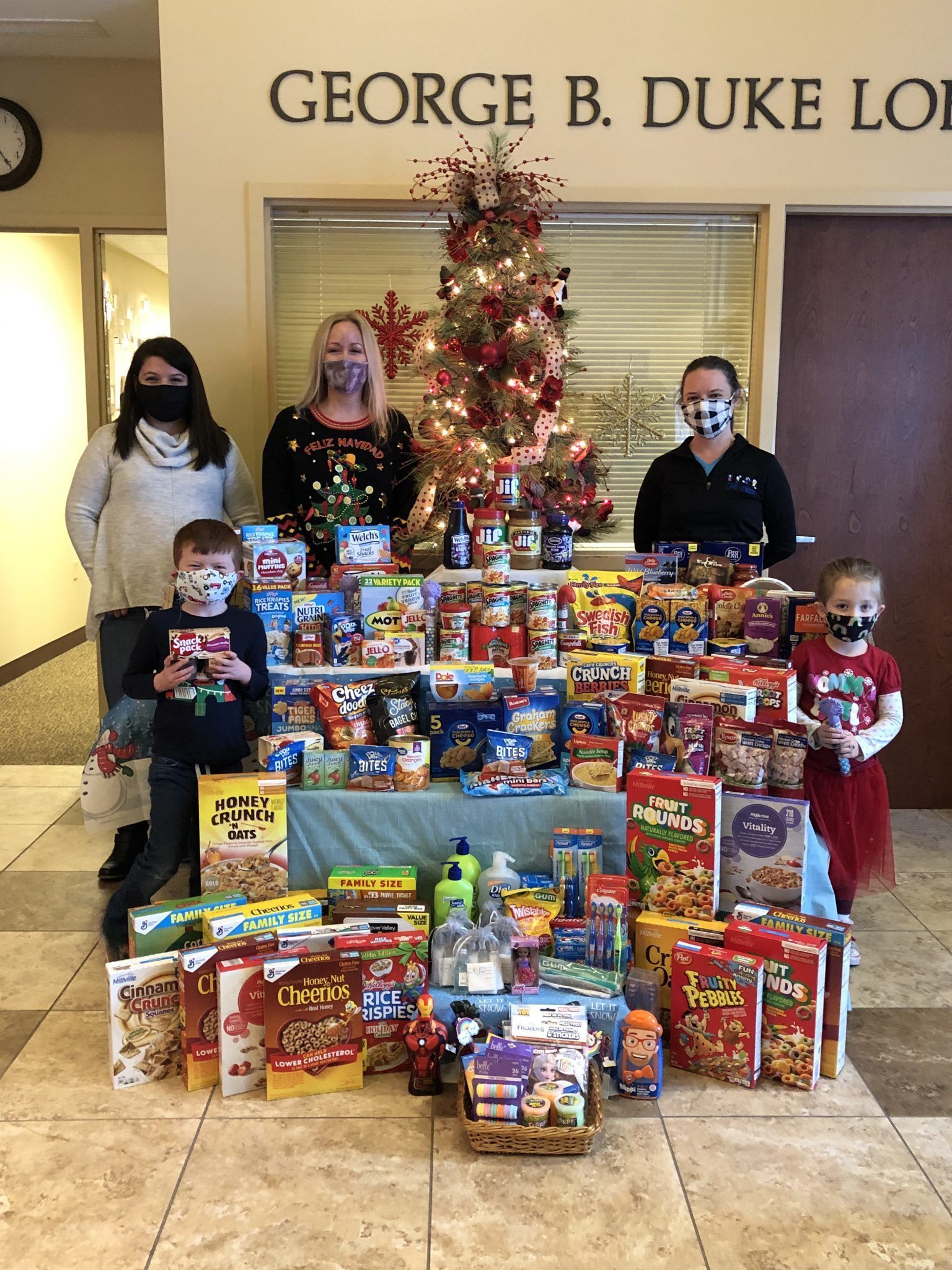 From left, preschool students Lucas Ball and Julianna Carlson stand next to the many donations. Pictured with the students are (back from left) Jolene Longley, Angela Erway, and Kimberly Engstrom.