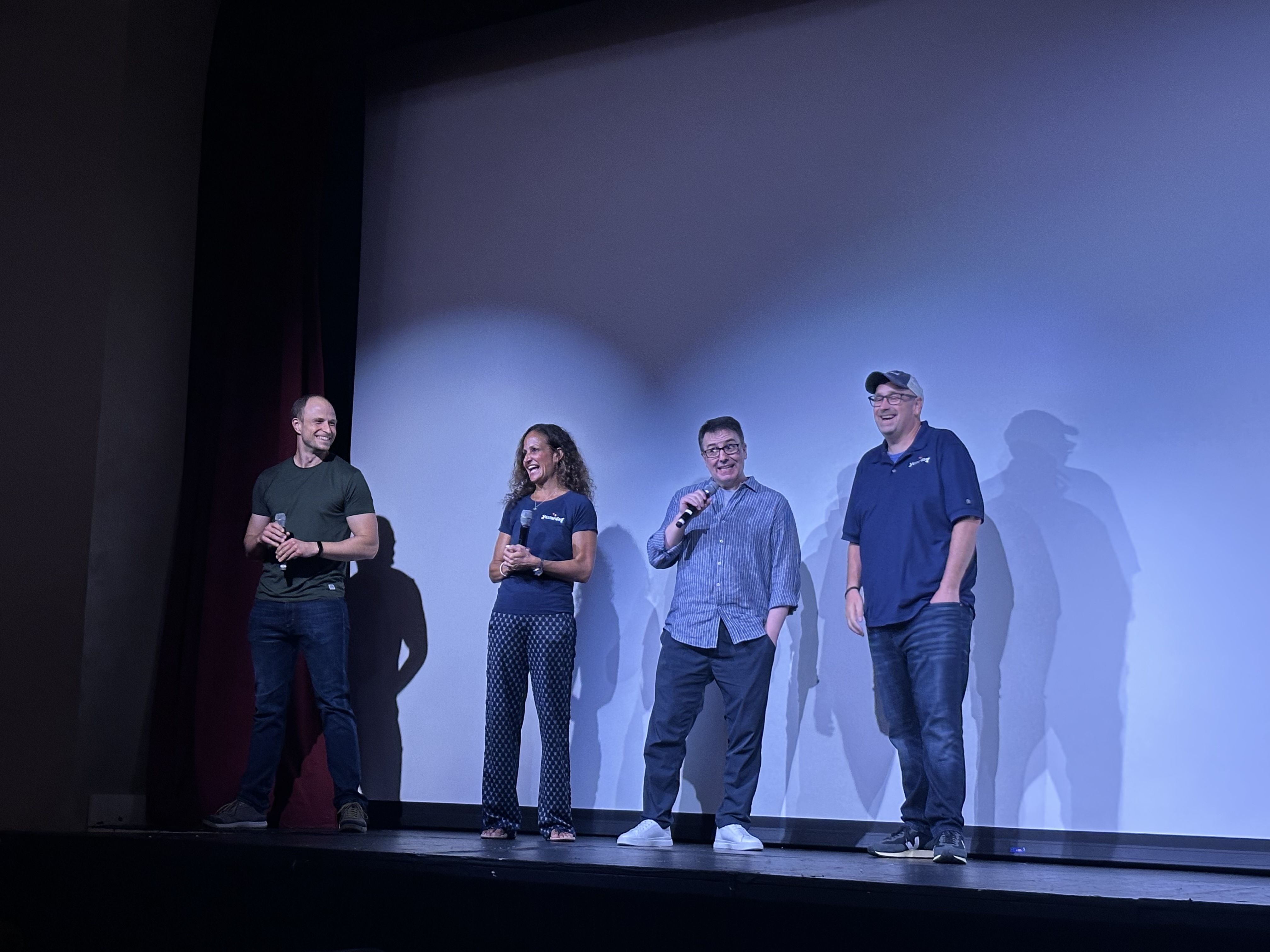 four people on stage at movie theatre