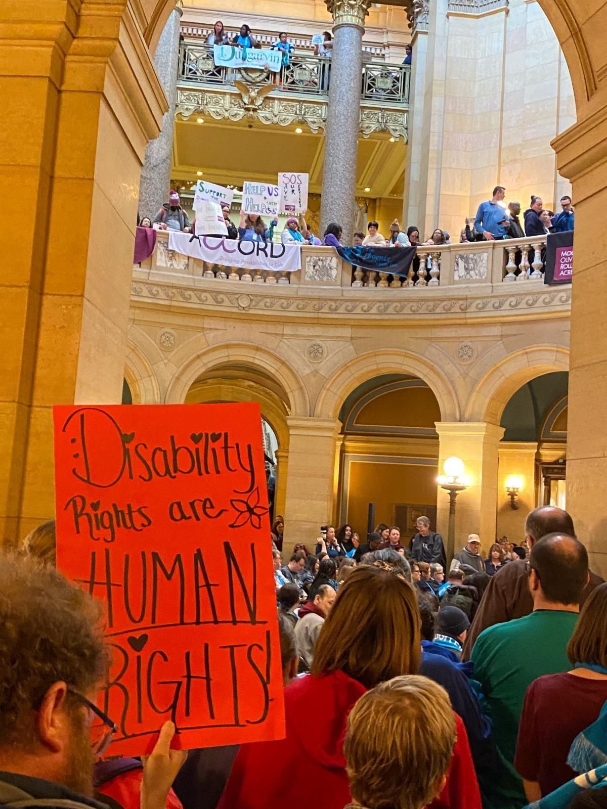 The crowd at the Disability Services Day at the Capitol. One person holds a sign that reads "Disability rights are human rights!"