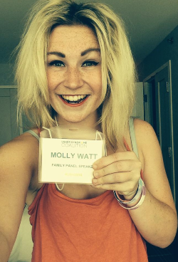 Molly Watt smiling and holding her USH2014 name badge