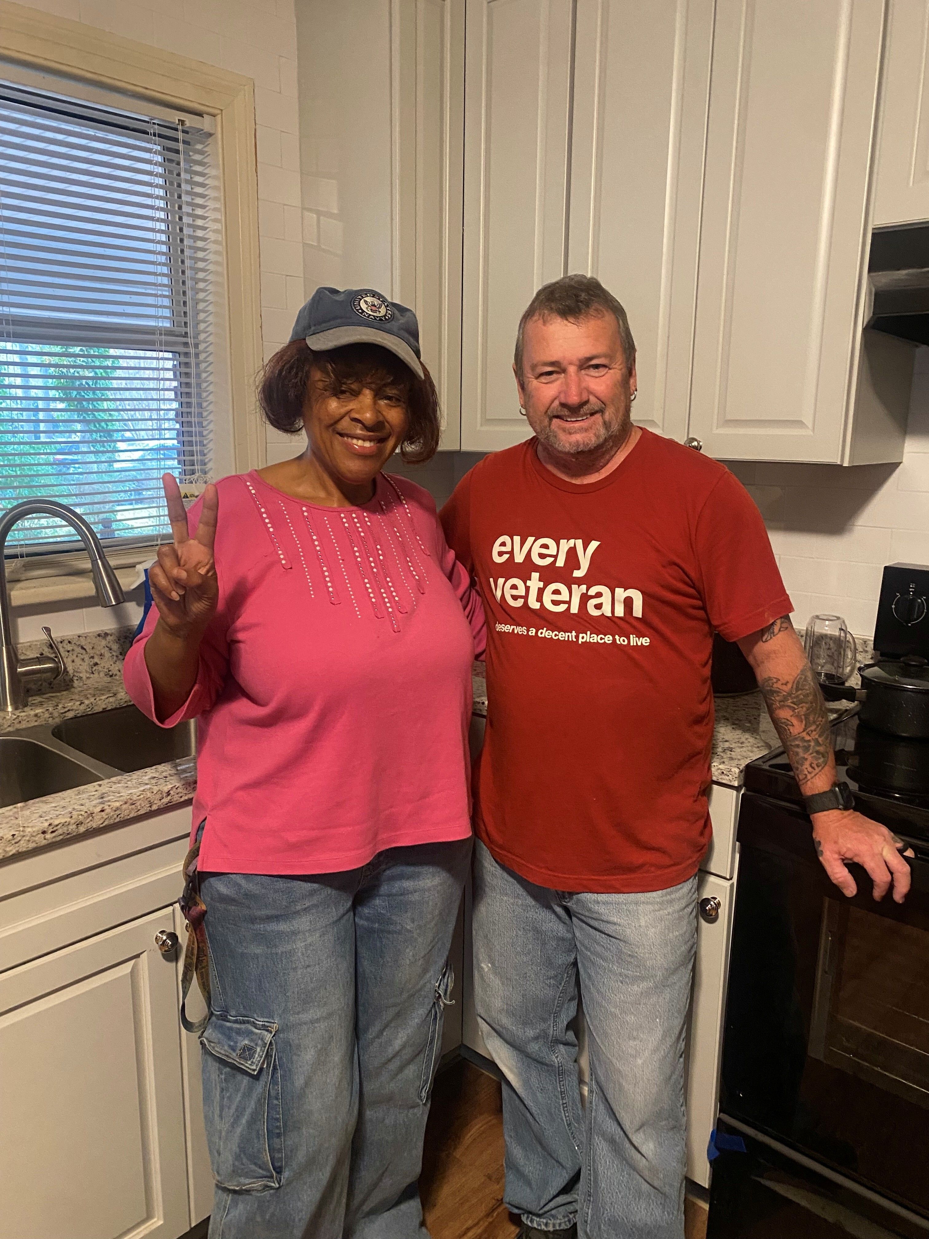 Construction director stands with home repair recipient