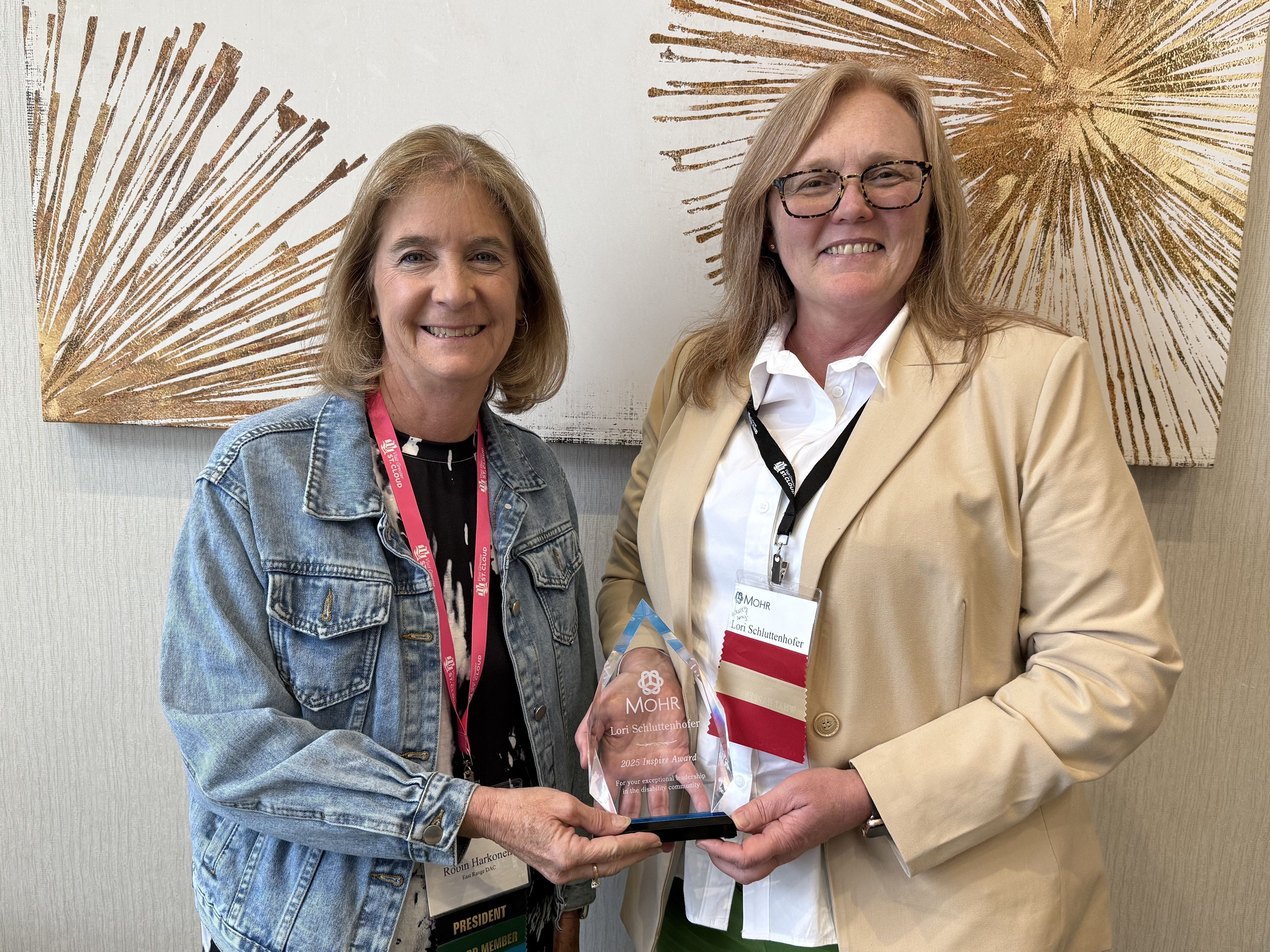 Lori Schluttenhofer, CEO of Services for Opportunity Partners in Minnetonkas accepting the 2025 Inspire Award from MOHR President Robin Harkonen