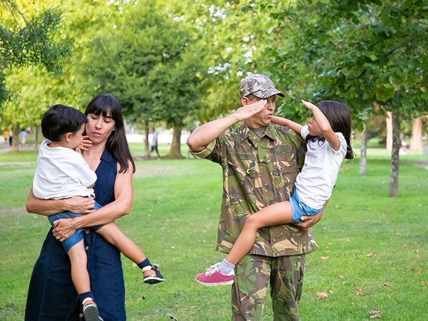 Man sitting on a sofa holding a military hat.