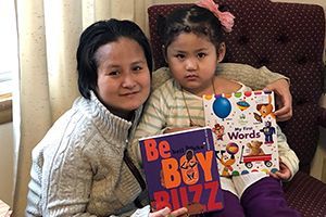 Sunday Paw and Juliana hold books