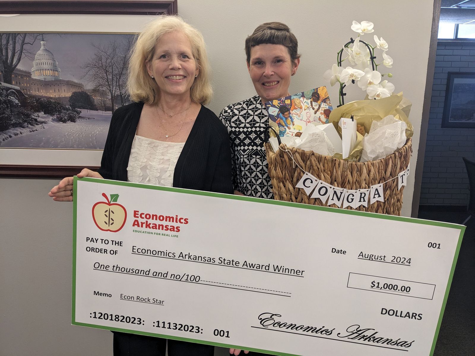 group of adults presenting large check and award to teacher