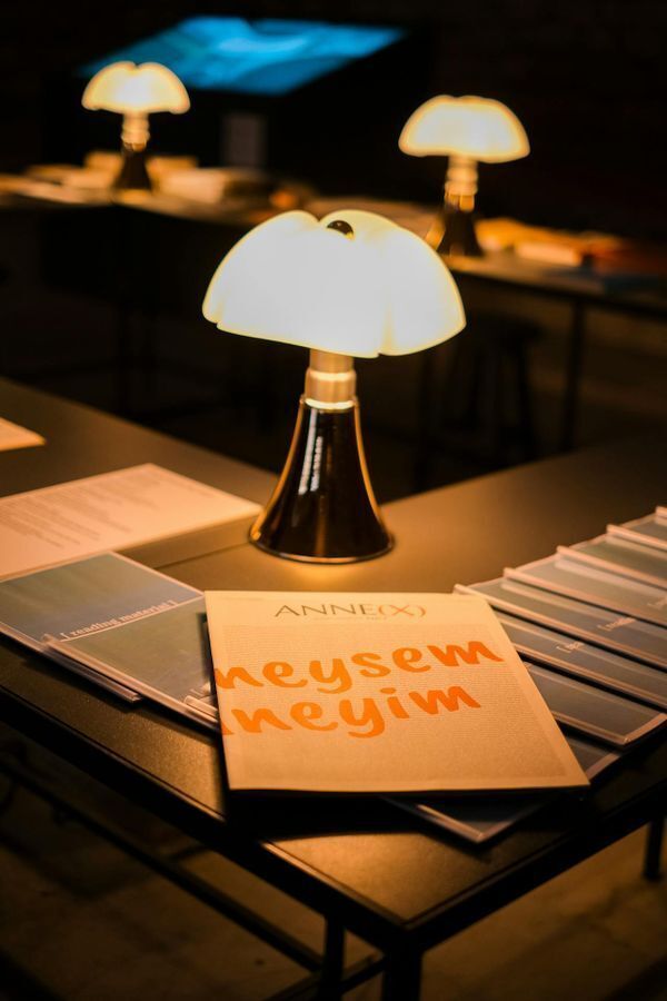 A printed booklet viewed under warm lighting, demonstrating how environmental light shifts corporate design colors without color management.