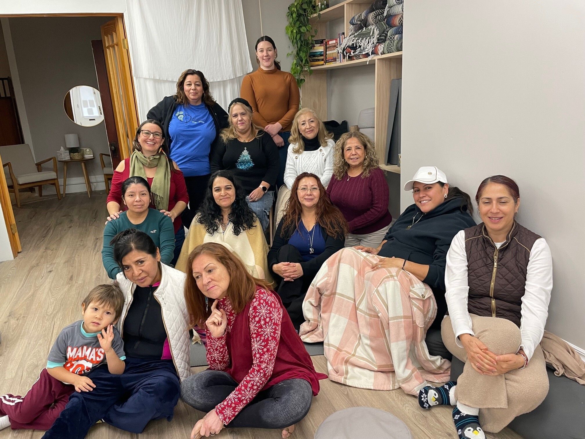 A group of individuals are gathered in a beige room posing for a group picture