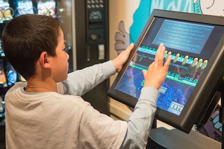 Young visitor at the National Cryptologic Museum discovers the Cipher Express Interactive Video Exhibit