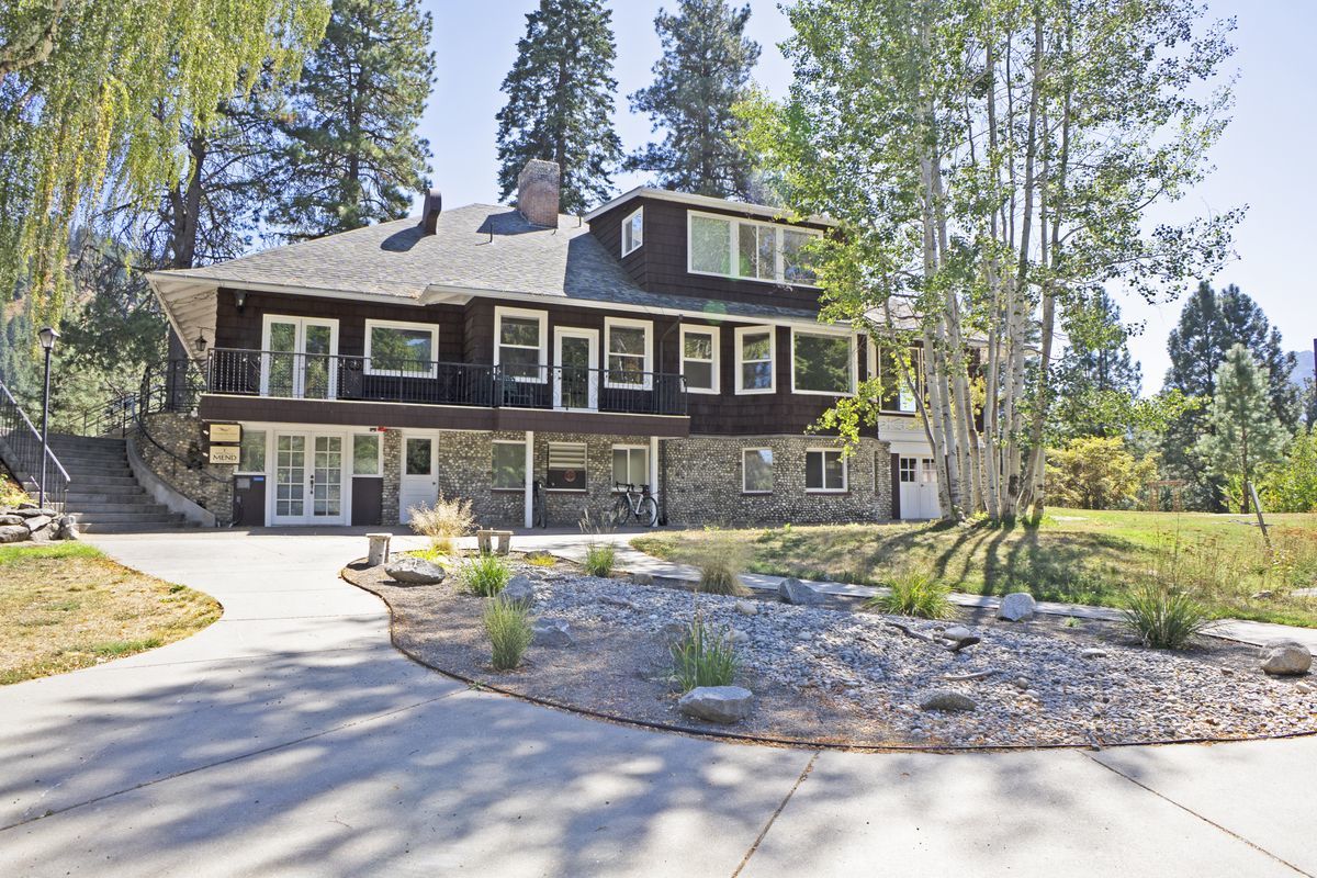 A brown building called the River Haus next to a garden and a pathway.