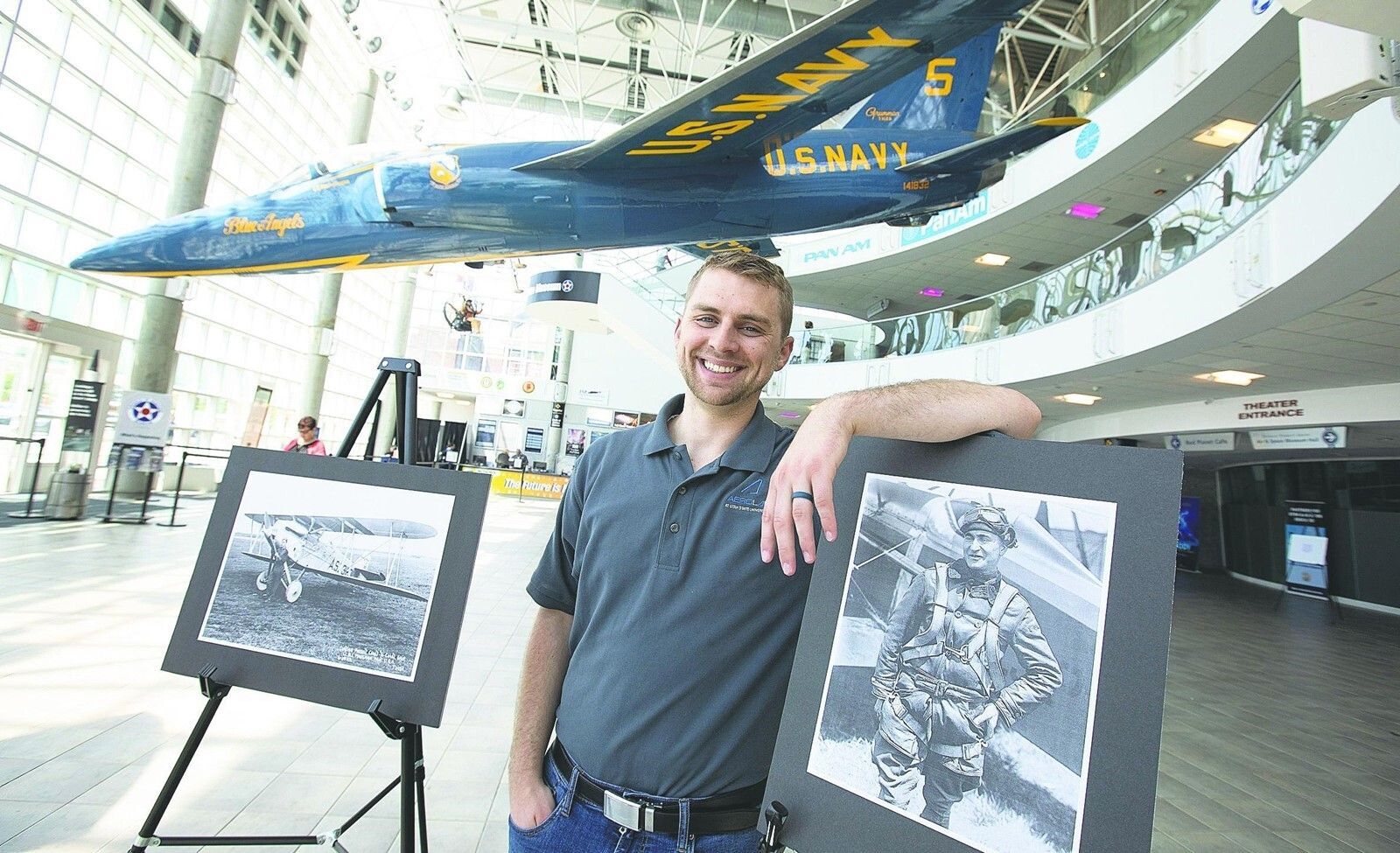 Nathan Hoch stands next to pictures of Russell Maughan, who made a transcontinental flight 100 years ago that Hoch plans to retrace.